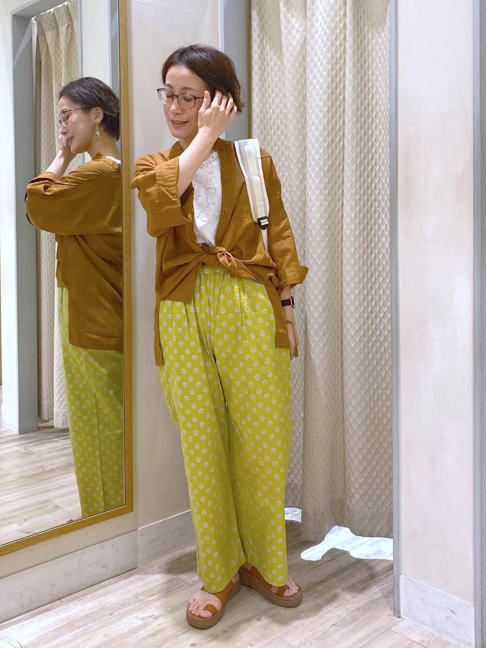 ブラウン系のサンダル、ホワイト系のバックパック/リュック、ホワイト系のタンクトップを着用したレディースの夏コーディネートの7枚目の写真