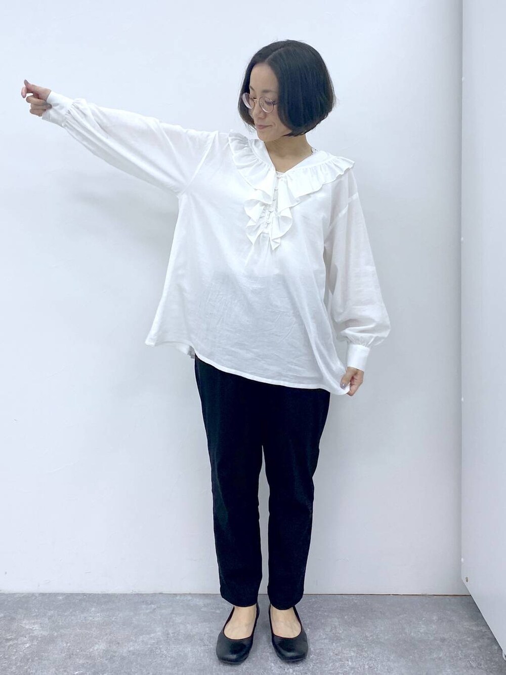 ホワイト系のシャツ/ブラウス、グレー系のタンクトップ、ブラック系のパンプスを着用したレディースの冬コーディネートの8枚目の写真