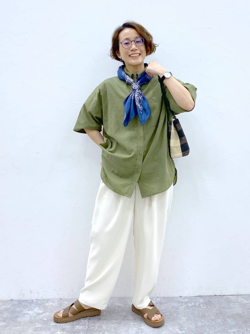 ブラウン系のサンダル、グリーン系のシャツ/ブラウス、ブラック系のトートバッグを着用したレディースの夏コーディネートの2枚目の写真