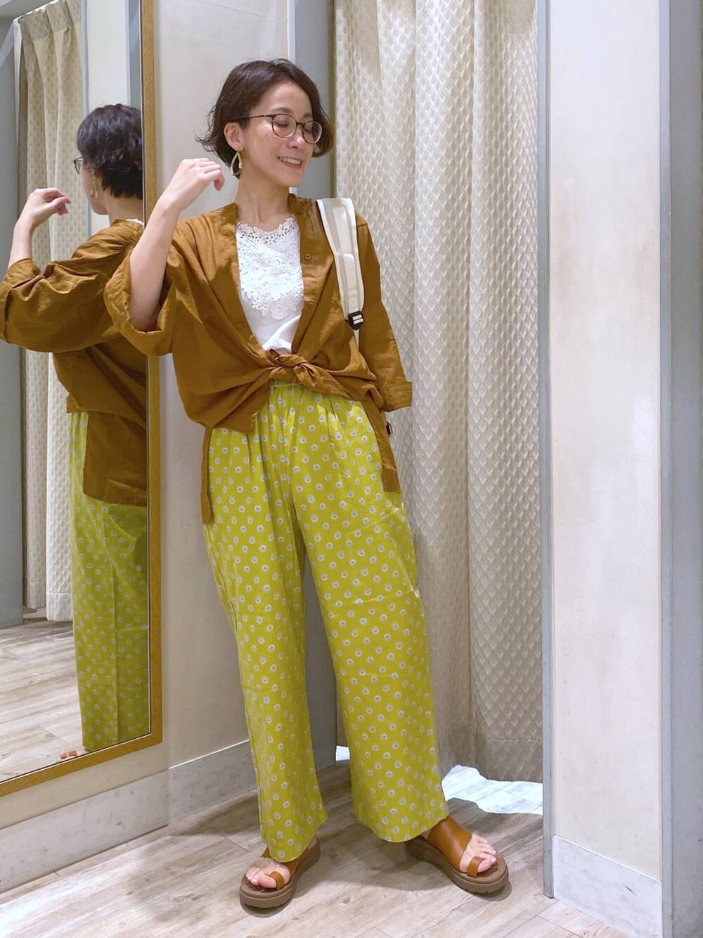 ブラウン系のサンダル、ホワイト系のバックパック/リュック、ホワイト系のタンクトップを着用したレディースの夏コーディネートの6枚目の写真