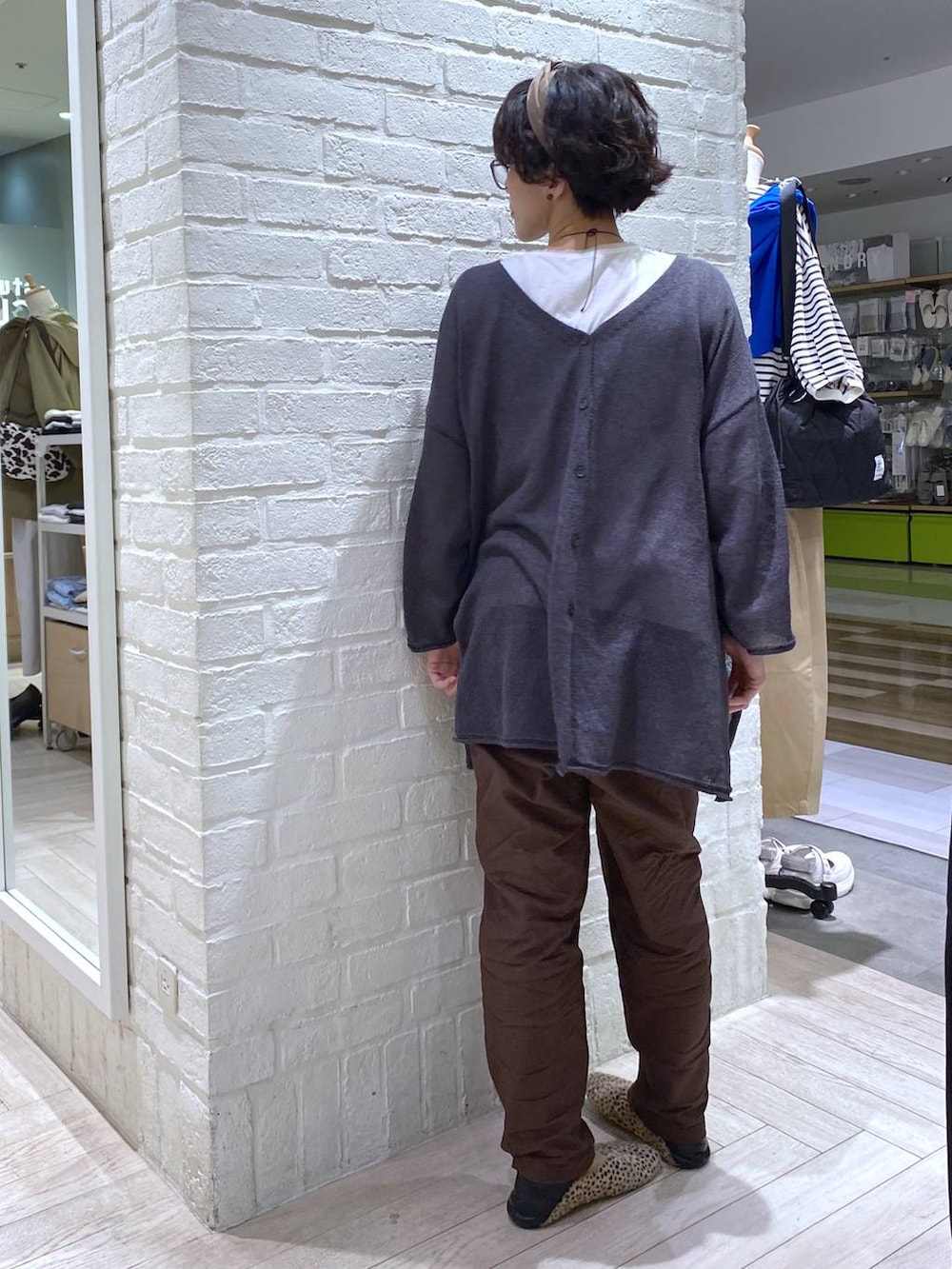 ホワイト系のTシャツ/カットソー、ブラウン系のその他パンツ、グレー系のカーディガン/ボレロを着用したレディースの春コーディネートの5枚目の写真