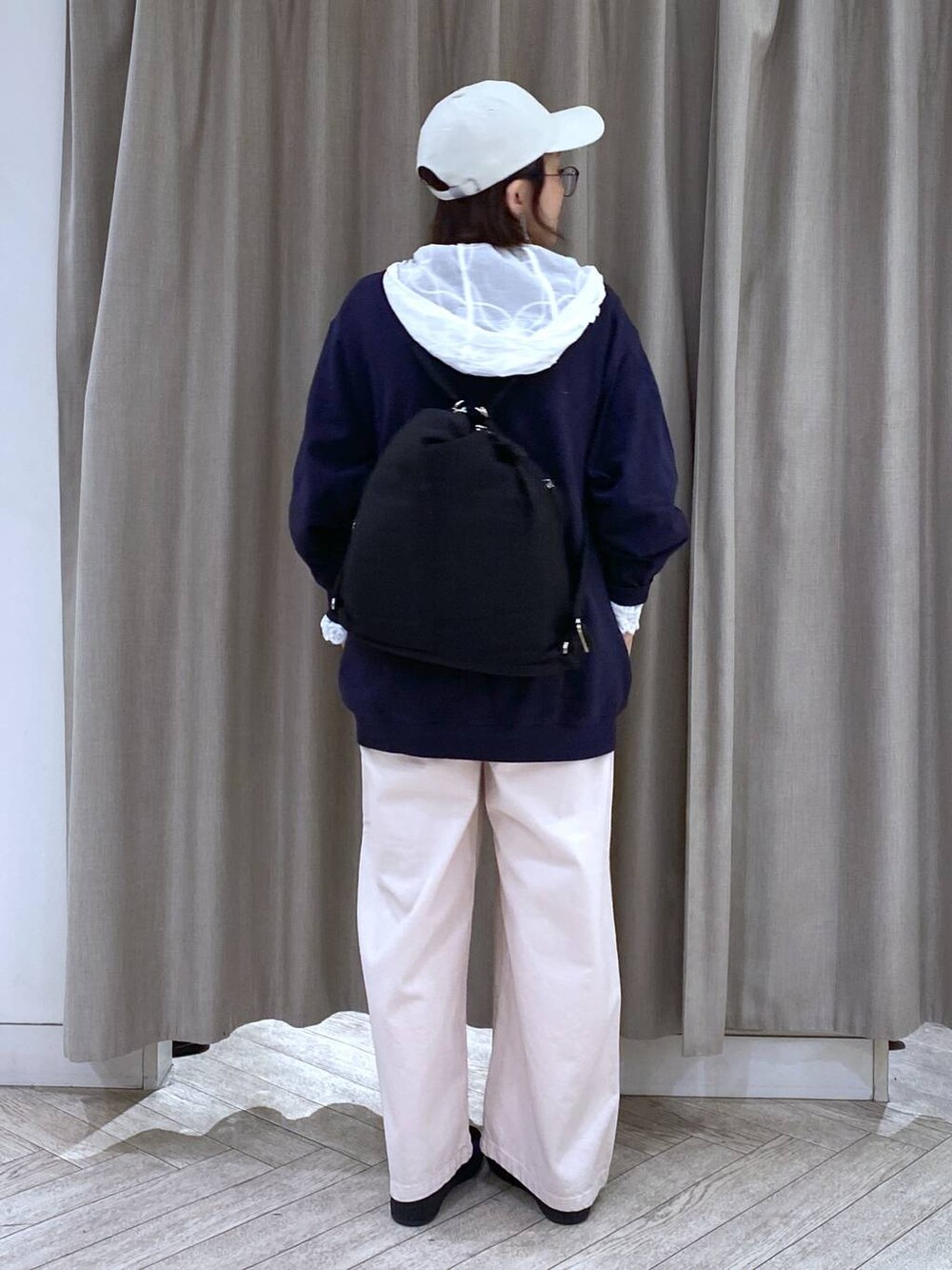 ブルー系のスウェット、ブラック系のショルダーバッグ、ピンク系のチノパンツを着用したレディースの冬コーディネートの5枚目の写真