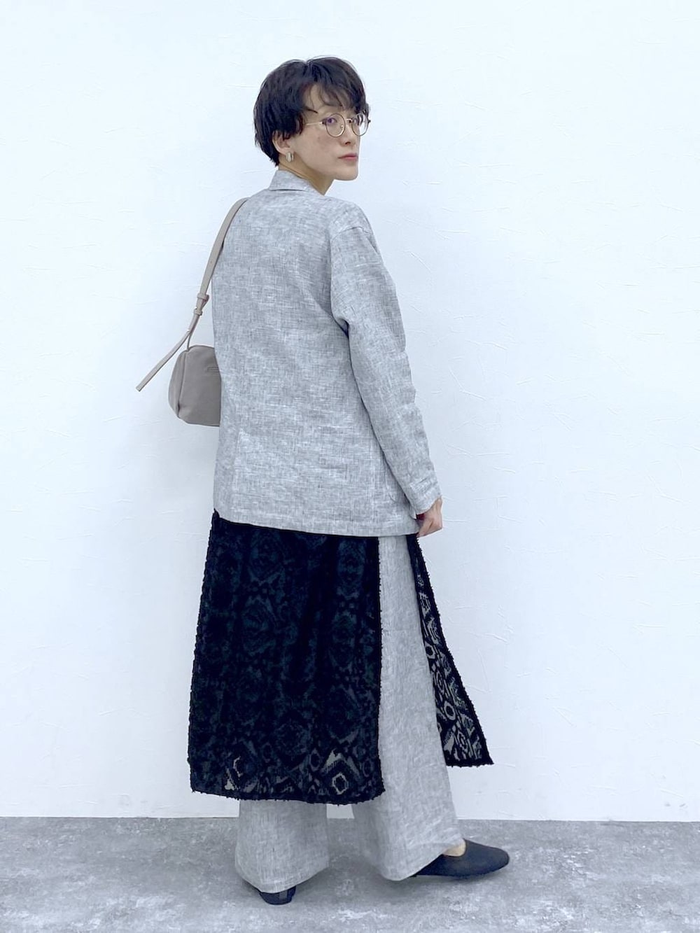 ブラック系のTシャツ/カットソー、ブラック系のベスト、グレー系のショルダーバッグを着用したレディースの春コーディネートの5枚目の写真