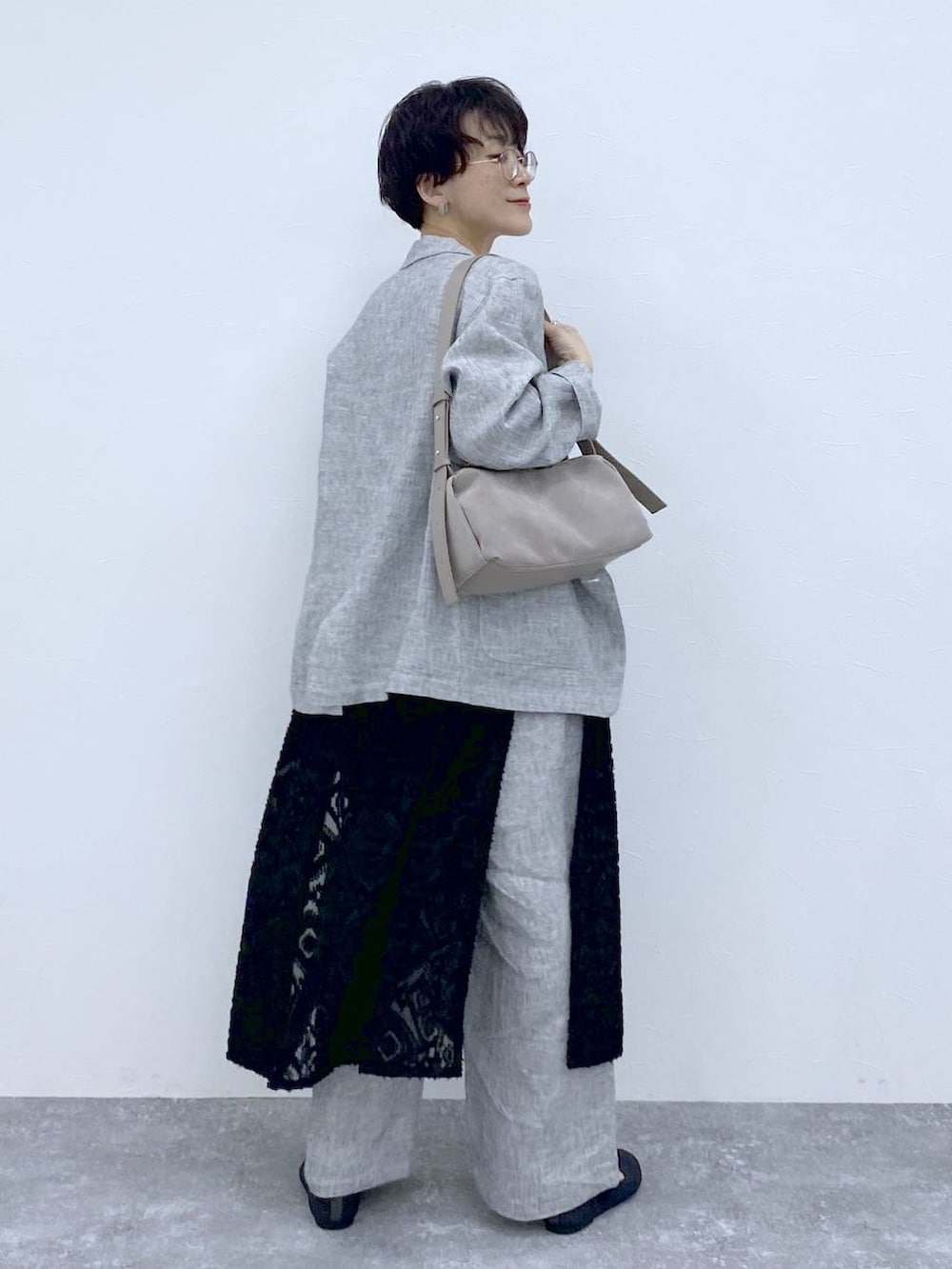 ブラック系のTシャツ/カットソー、ブラック系のベスト、グレー系のショルダーバッグを着用したレディースの春コーディネートの6枚目の写真