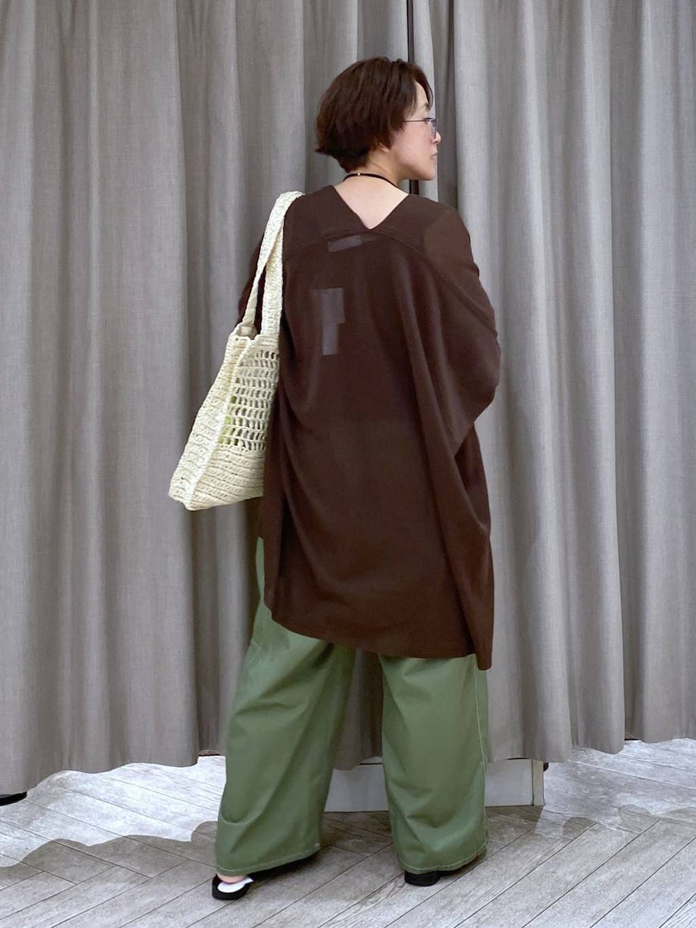 ブラック系のタンクトップ、ベージュ系のトートバッグ、ブラック系のサンダルを着用したレディースの夏コーディネートの4枚目の写真