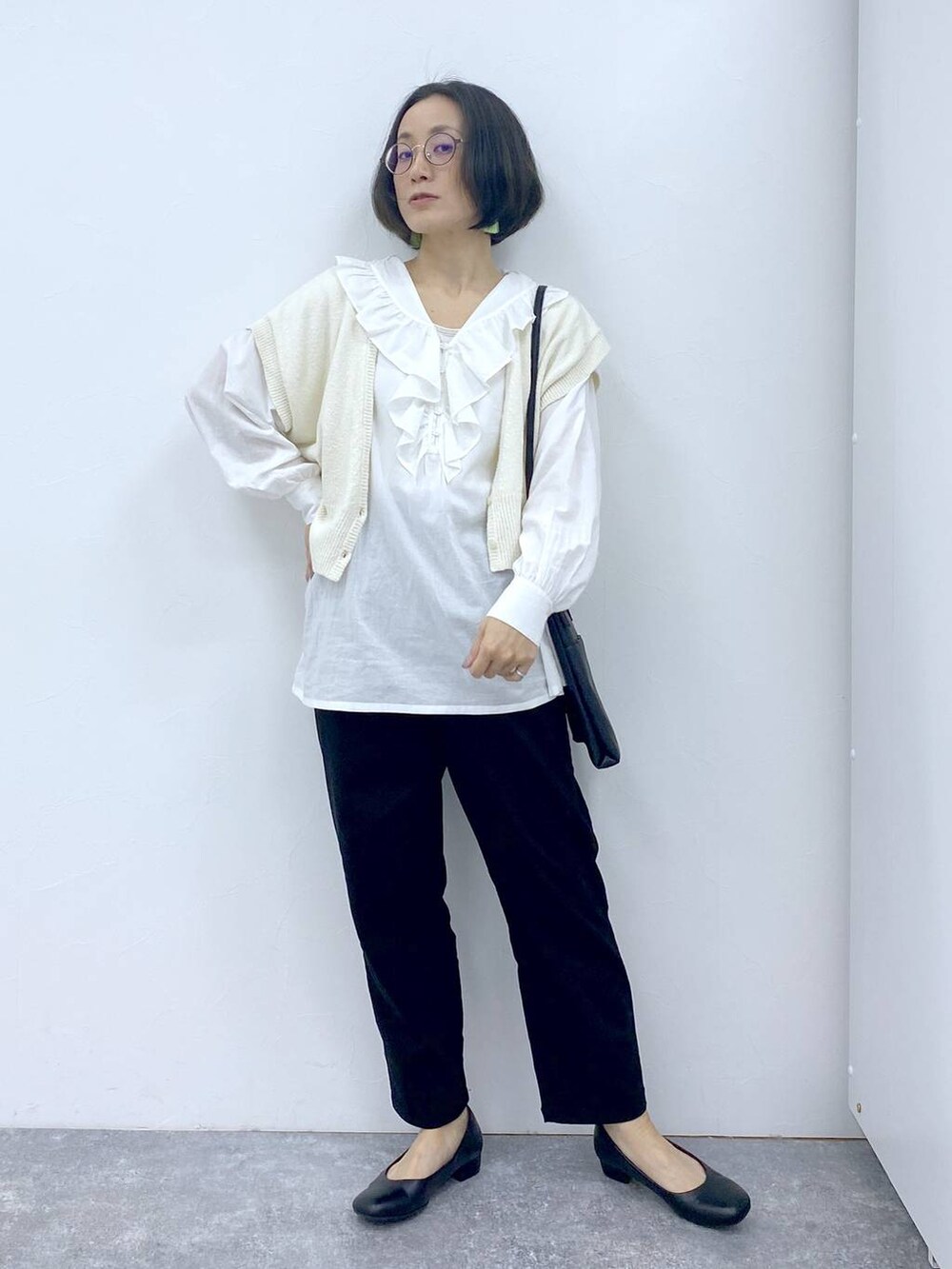 ホワイト系のシャツ/ブラウス、グレー系のタンクトップ、ブラック系のパンプスを着用したレディースの冬コーディネートの9枚目の写真