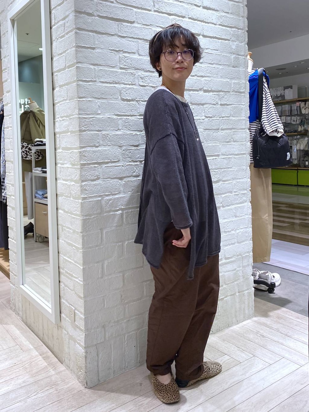 ホワイト系のTシャツ/カットソー、ブラウン系のその他パンツ、グレー系のカーディガン/ボレロを着用したレディースの春コーディネートの7枚目の写真