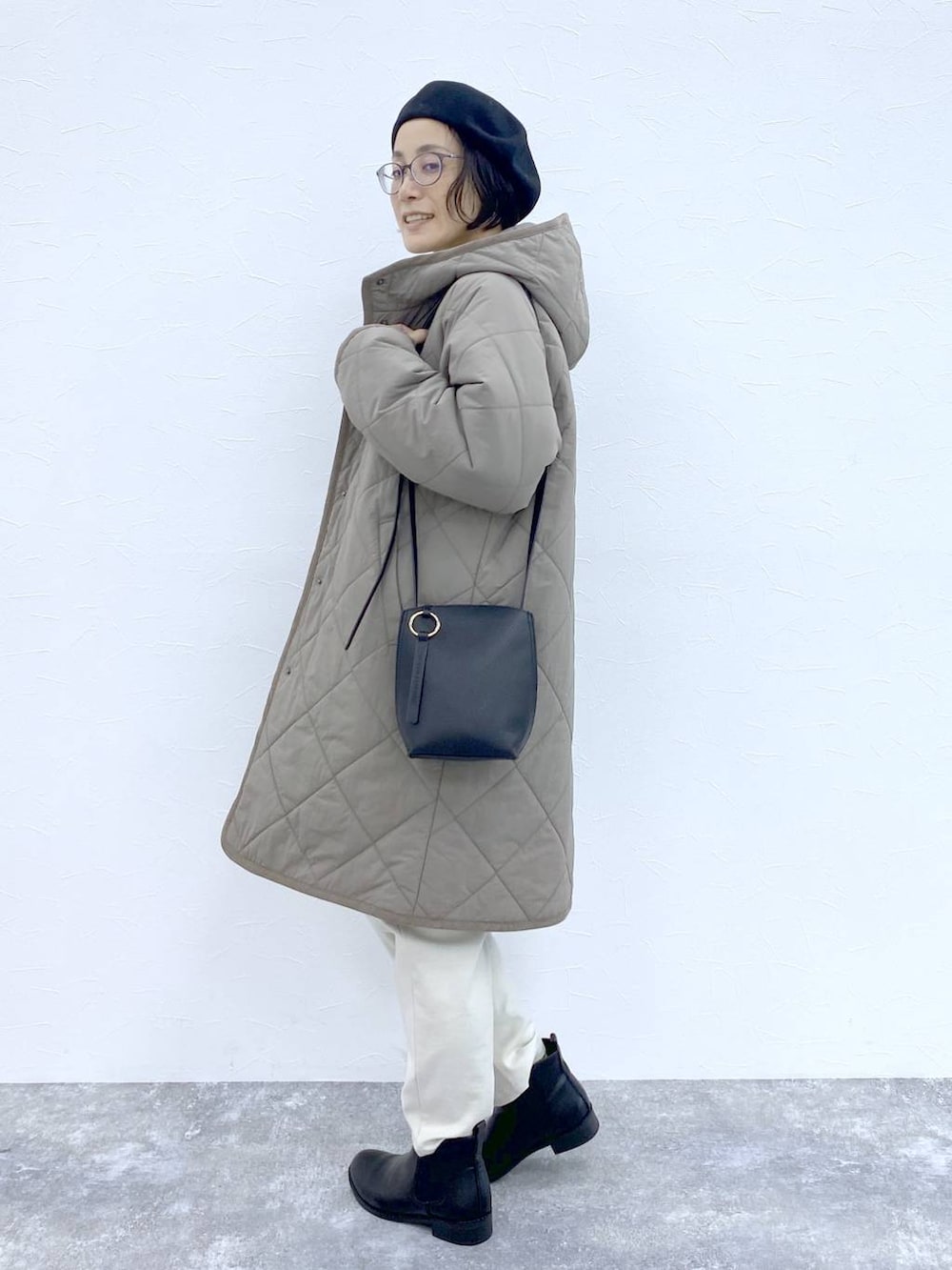 ブラック系のブーツ、ブラウン系のダウンジャケット/コート、ブラック系のショルダーバッグを着用したレディースの冬コーディネートの3枚目の写真