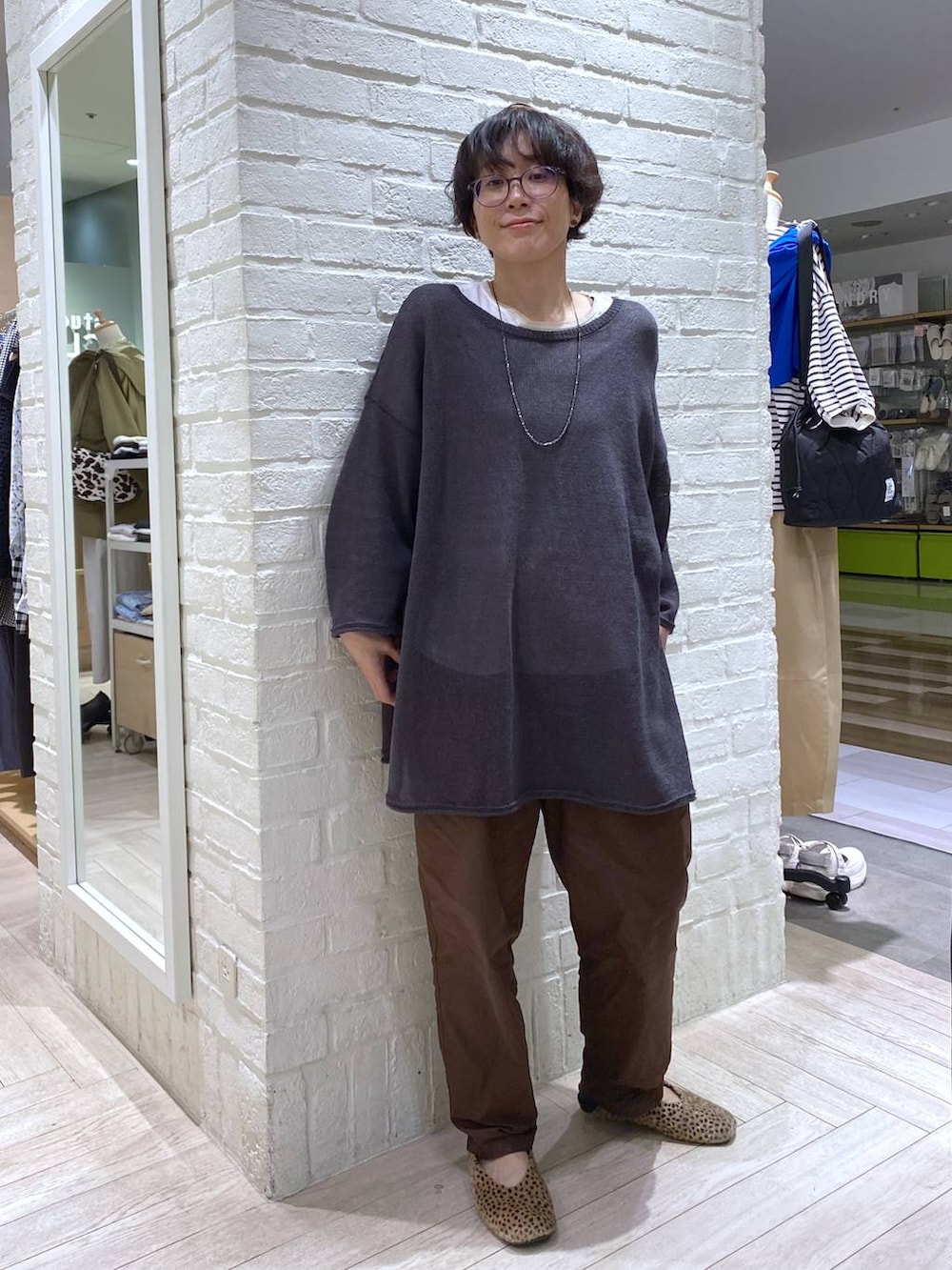 ホワイト系のTシャツ/カットソー、ブラウン系のその他パンツ、グレー系のカーディガン/ボレロを着用したレディースの春コーディネートの2枚目の写真