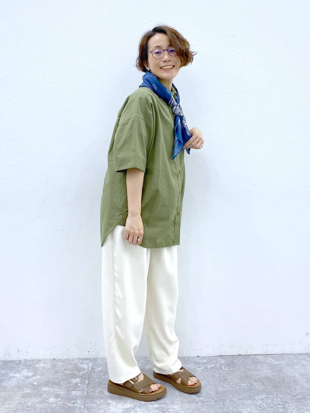 ブラウン系のサンダル、グリーン系のシャツ/ブラウス、ブラック系のトートバッグを着用したレディースの夏コーディネートの6枚目の写真