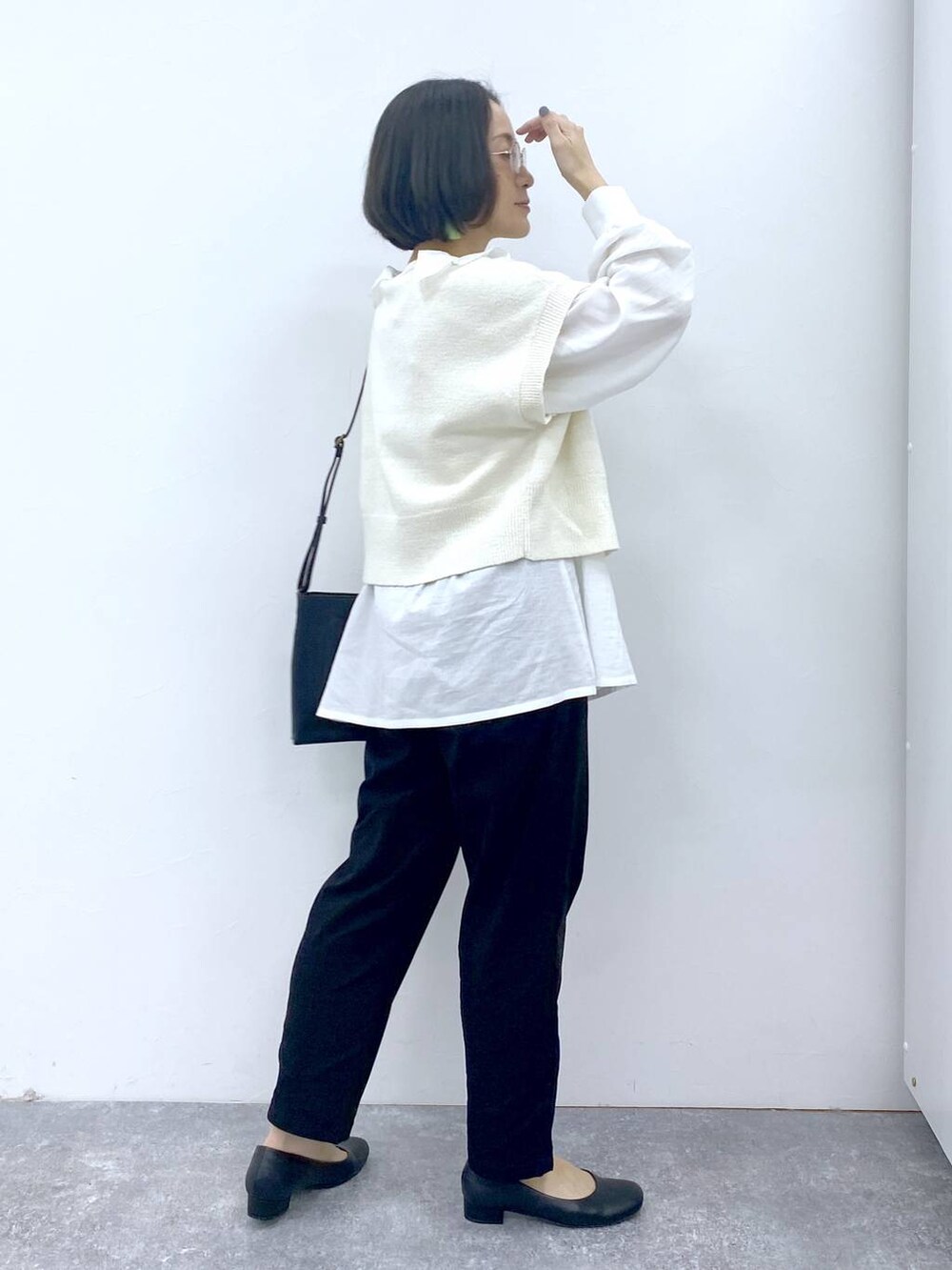 ホワイト系のシャツ/ブラウス、グレー系のタンクトップ、ブラック系のパンプスを着用したレディースの冬コーディネートの6枚目の写真