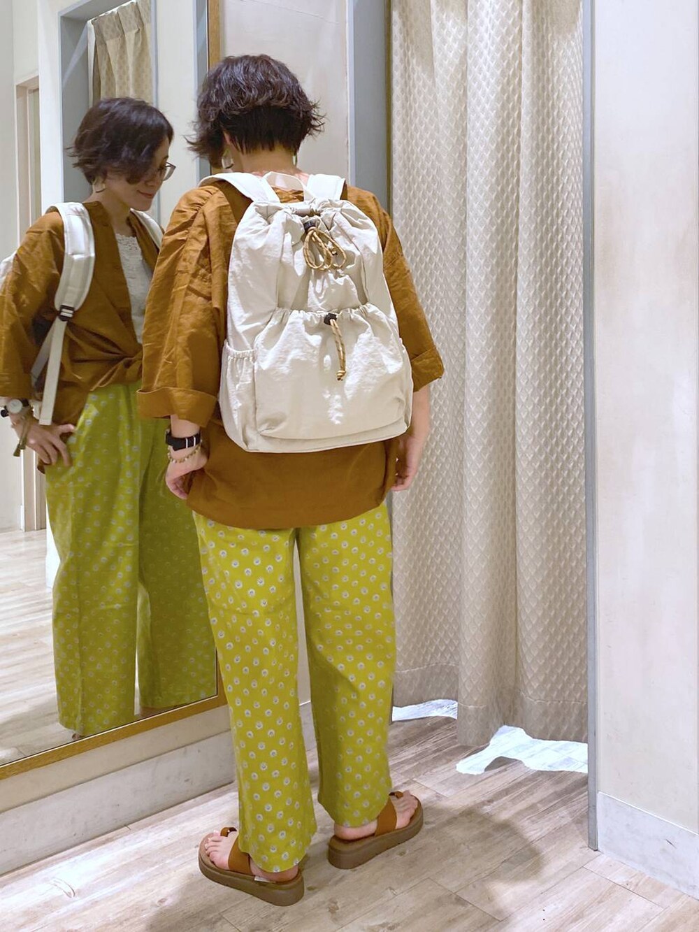 ブラウン系のサンダル、ホワイト系のバックパック/リュック、ホワイト系のタンクトップを着用したレディースの夏コーディネートの4枚目の写真