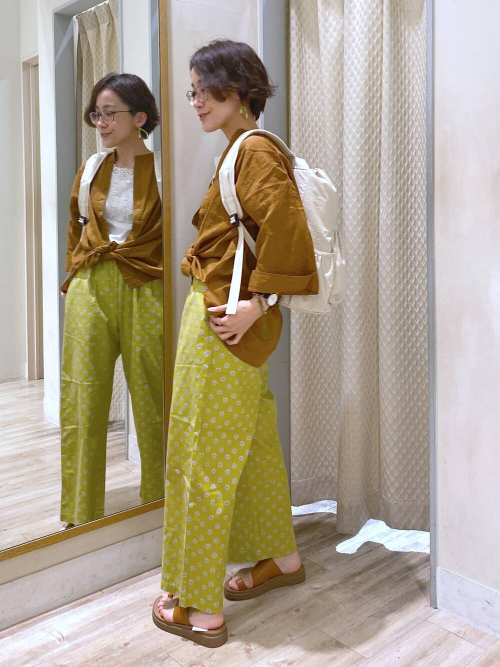 ブラウン系のサンダル、ホワイト系のバックパック/リュック、ホワイト系のタンクトップを着用したレディースの夏コーディネートの3枚目の写真