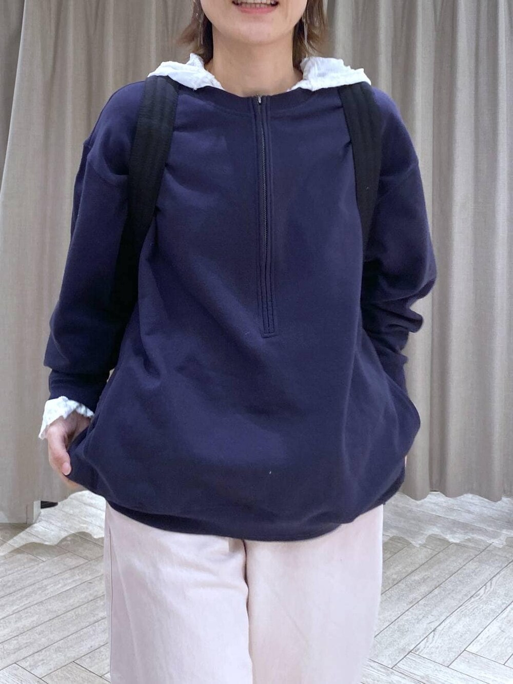 ブルー系のスウェット、ブラック系のショルダーバッグ、ピンク系のチノパンツを着用したレディースの冬コーディネートの8枚目の写真