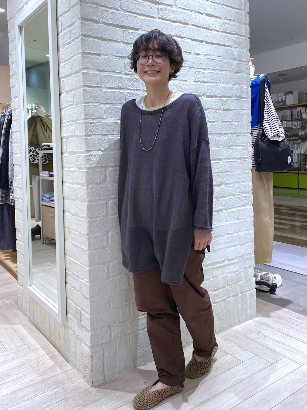 ホワイト系のTシャツ/カットソー、ブラウン系のその他パンツ、グレー系のカーディガン/ボレロを着用したレディースの春コーディネートの3枚目の写真