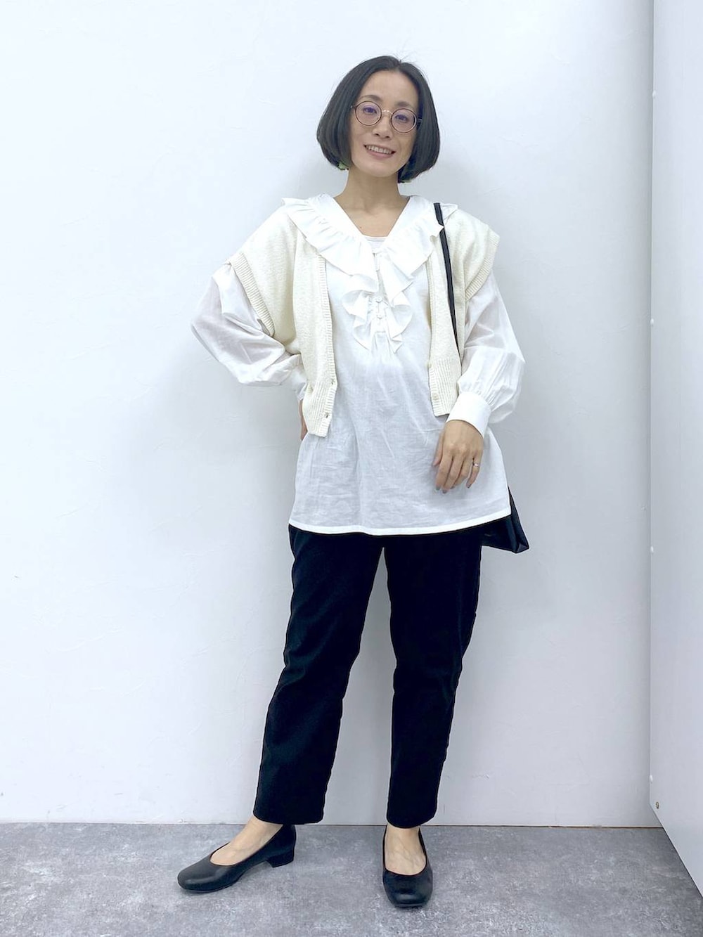 ホワイト系のシャツ/ブラウス、グレー系のタンクトップ、ブラック系のパンプスを着用したレディースの冬コーディネートの2枚目の写真