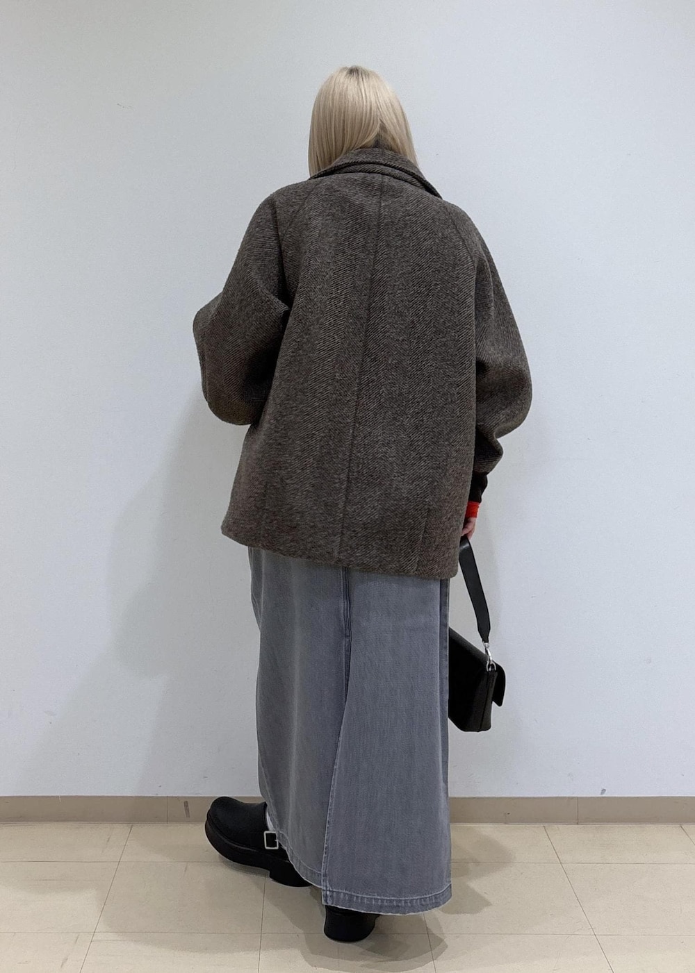 グレー系のデニムスカート、ブラウン系のその他アウター、レッド系のTシャツ/カットソーを着用したレディースの秋コーディネートの3枚目の写真