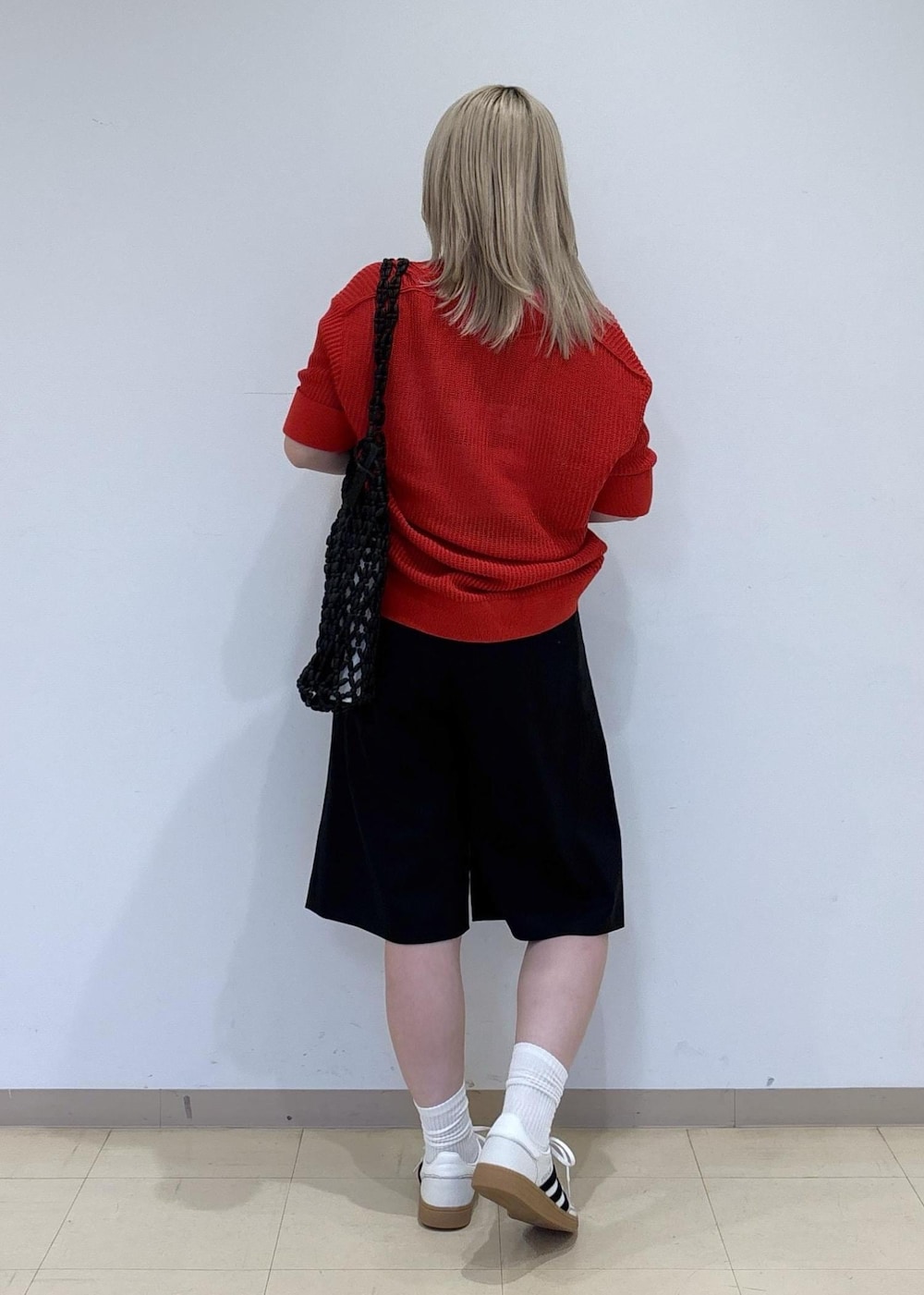 ブラック系のトートバッグ、ブラック系のその他パンツ、レッド系のニット/セーターを着用したレディースの春コーディネートの3枚目の写真