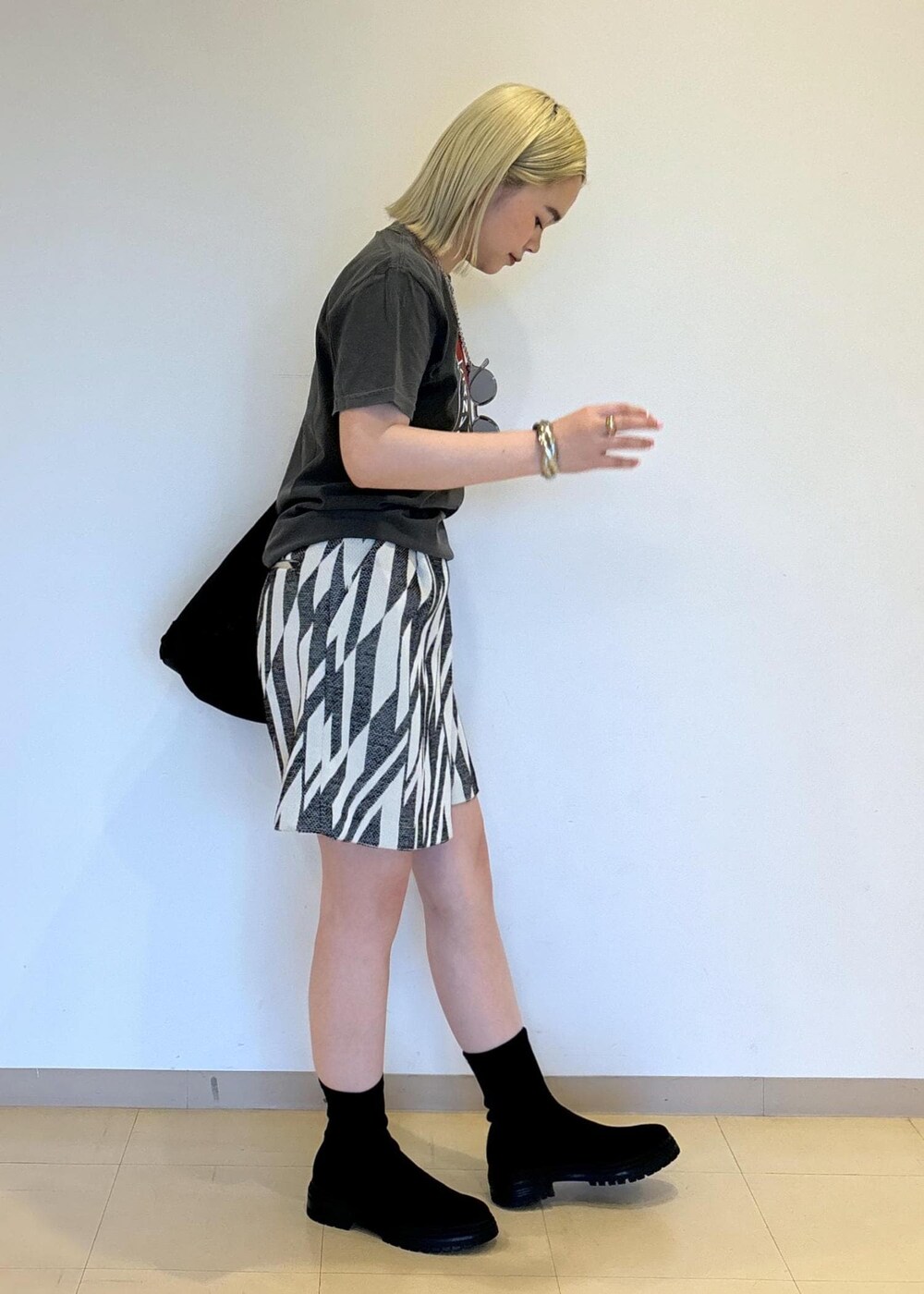 ブラック系のブーツ、ブラック系のショルダーバッグ、ブラック系のその他パンツを着用したレディースの春コーディネートの4枚目の写真