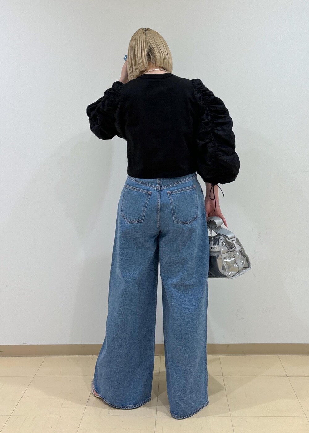 ブルー系のデニムパンツ、シルバー系のショルダーバッグ、シルバー系のサンダルを着用したレディースの春コーディネートの3枚目の写真