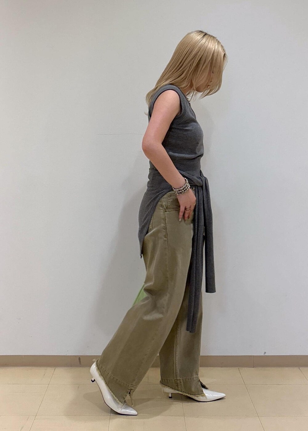 ホワイト系のパンプス、グレー系のニット/セーター、ベージュ系のデニムパンツを着用したレディースの夏コーディネートの4枚目の写真