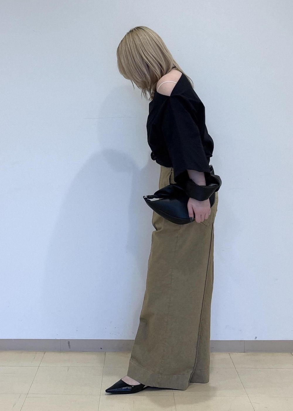 ブラック系のパンプス、ブラック系のショルダーバッグ、ベージュ系のデニムパンツを着用したレディースの春コーディネートの2枚目の写真