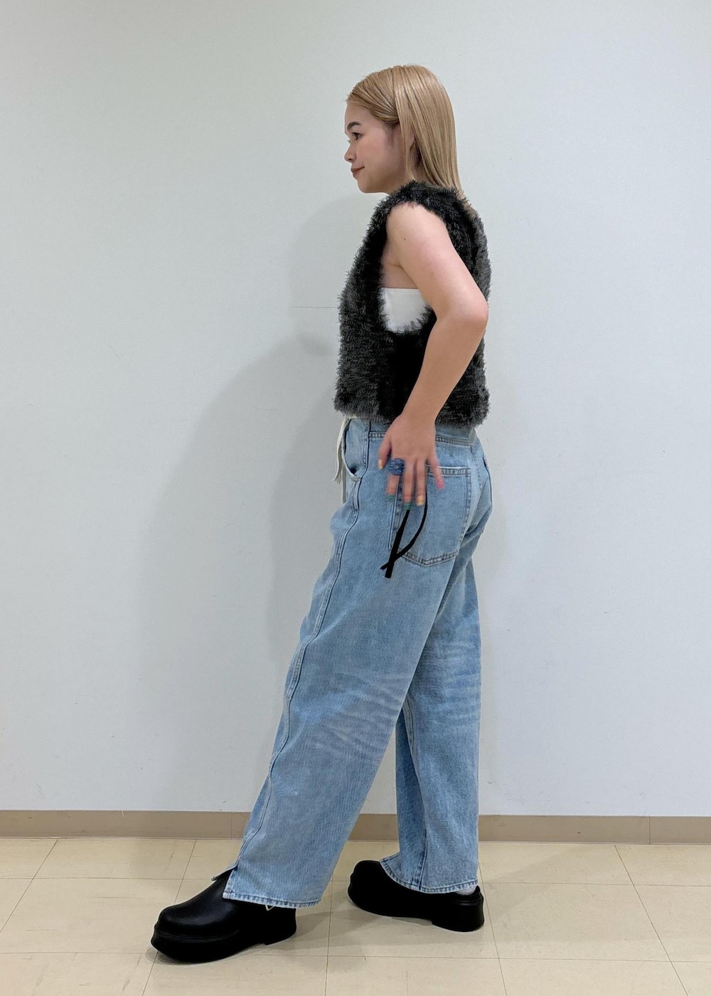 ホワイト系のキャミソール、ブラック系のサンダル、グレー系のベストを着用したレディースの夏コーディネートの2枚目の写真