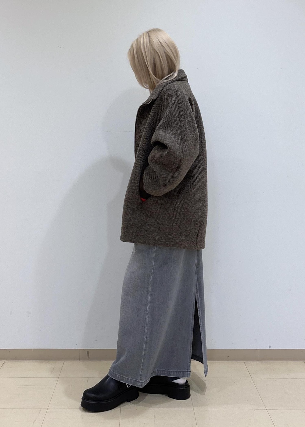 グレー系のデニムスカート、ブラウン系のその他アウター、レッド系のTシャツ/カットソーを着用したレディースの秋コーディネートの2枚目の写真