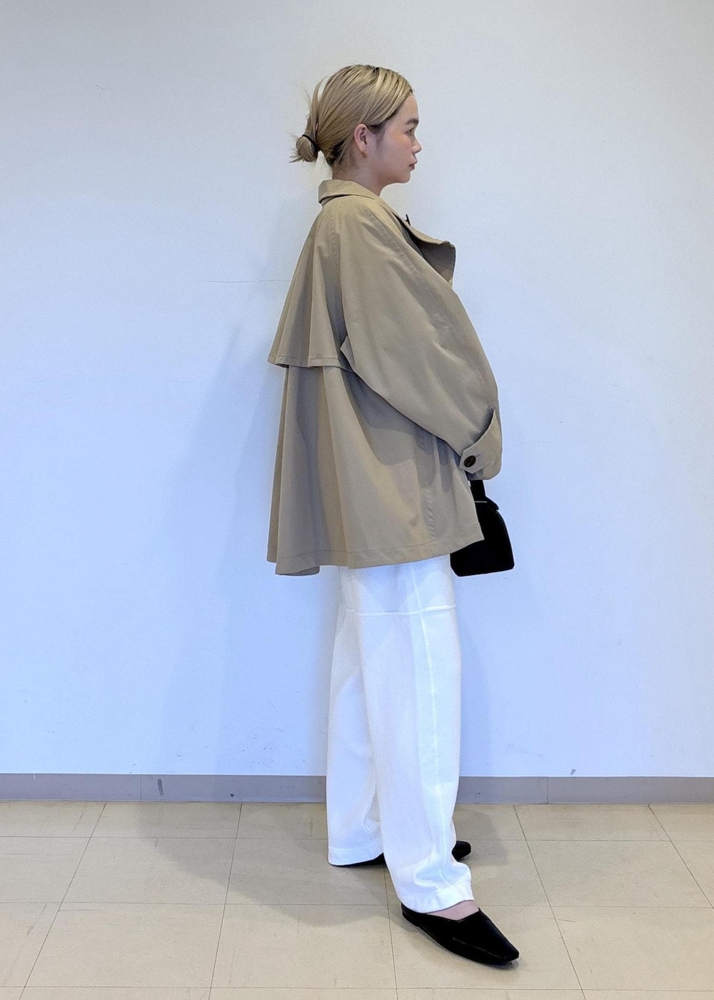 ベージュ系のトレンチコート、レッド系のTシャツ/カットソー、ブラック系のサンダルを着用したレディースの春コーディネートの4枚目の写真