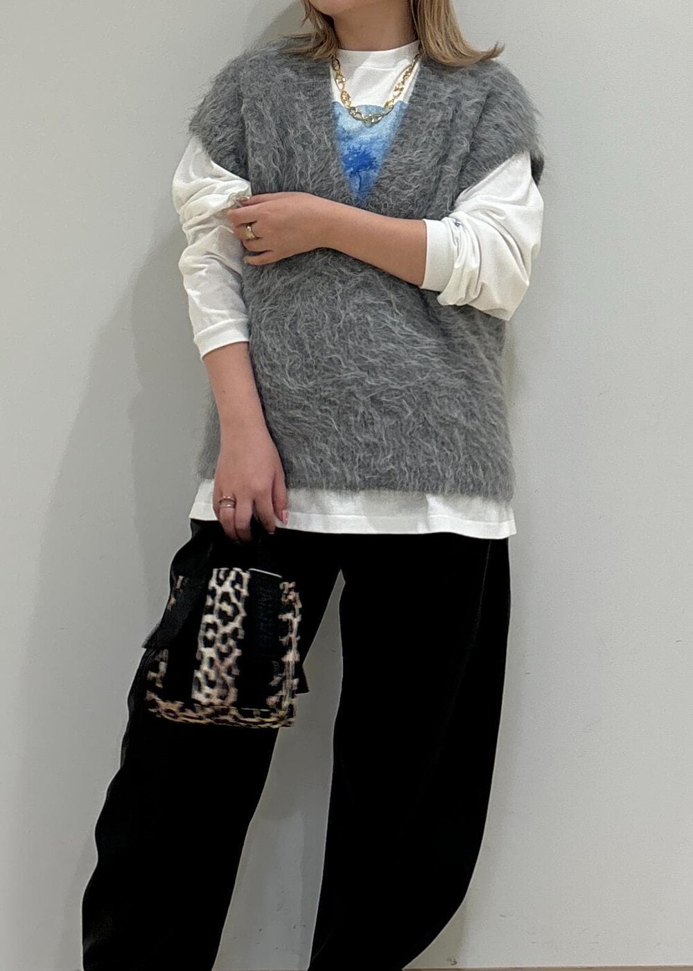 ベージュ系のトートバッグ、ホワイト系のTシャツ/カットソー、グレー系のニット/セーターを着用したレディースの秋コーディネートの6枚目の写真