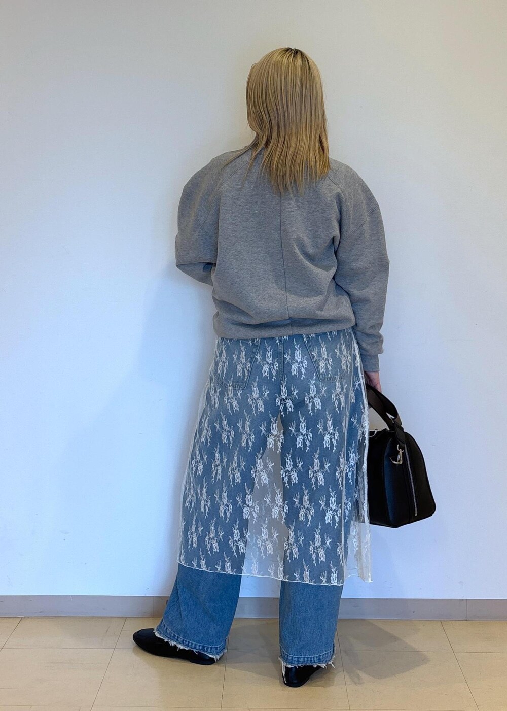 ホワイト系のTシャツ/カットソー、ブラック系のレインシューズ、グレー系のスウェットを着用したレディースの冬コーディネートの3枚目の写真