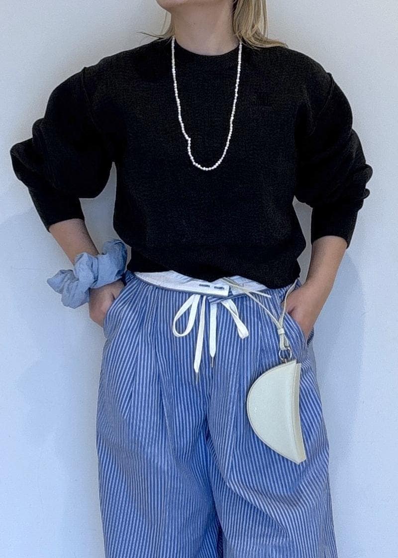 ブルー系のスラックス、グレー系のニット/セーターを着用したレディースの秋コーディネートの5枚目の写真