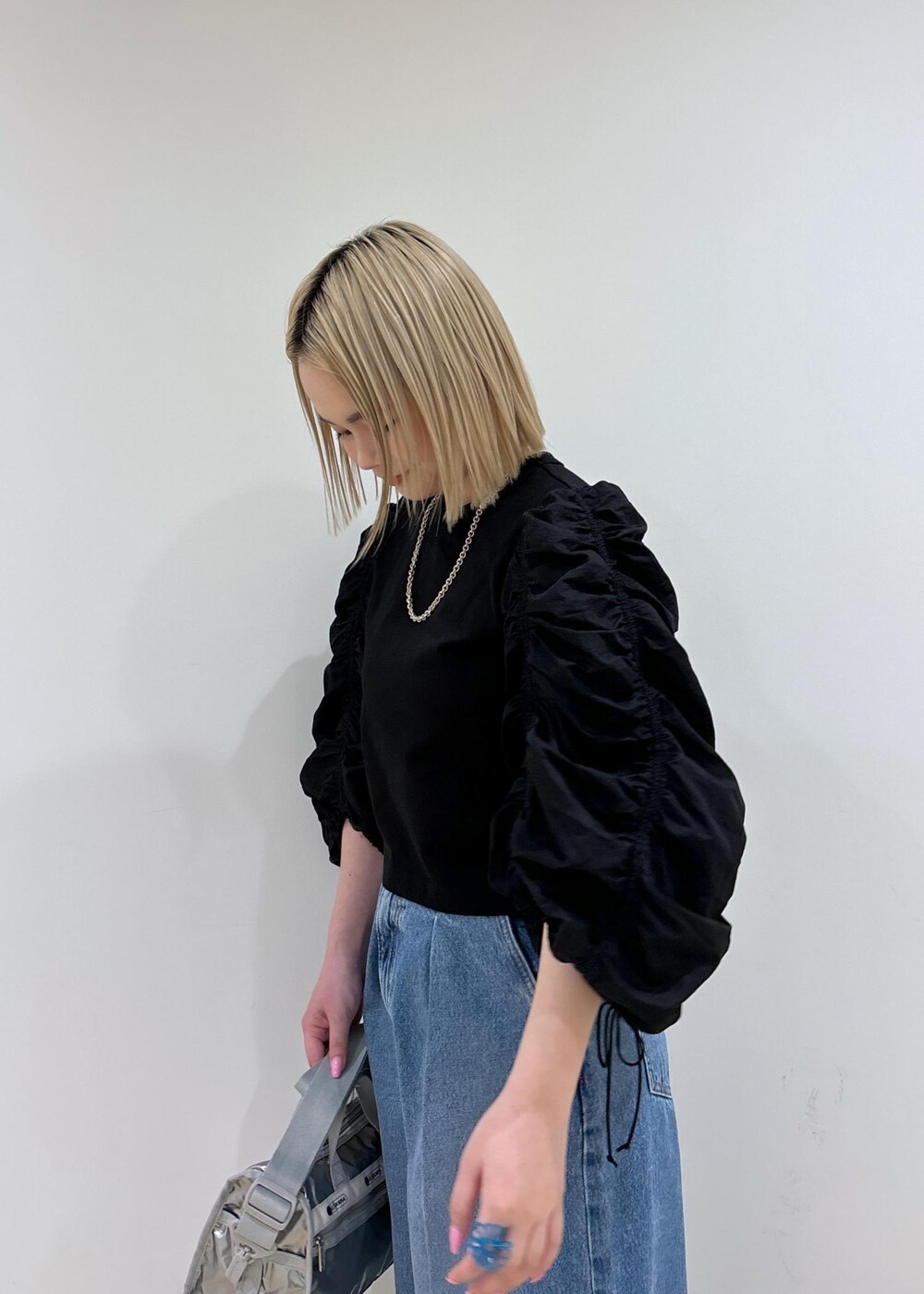 ブルー系のデニムパンツ、シルバー系のショルダーバッグ、シルバー系のサンダルを着用したレディースの春コーディネートの6枚目の写真