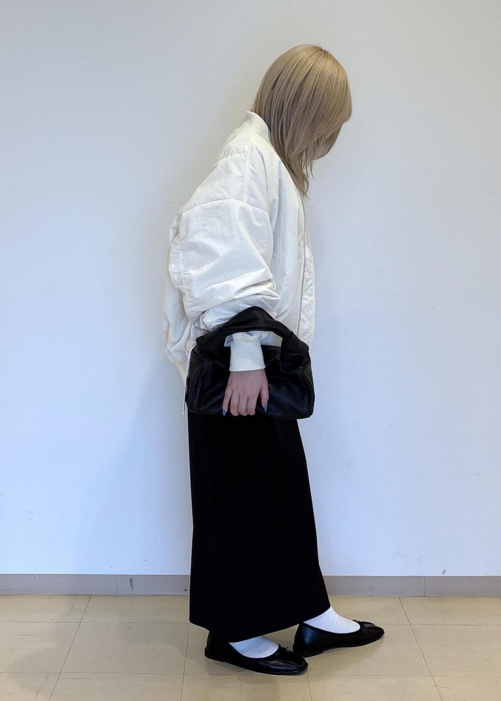 ブラック系のハンドバッグ、ホワイト系のTシャツ/カットソー、ブラック系のバレエシューズを着用したレディースの冬コーディネートの4枚目の写真