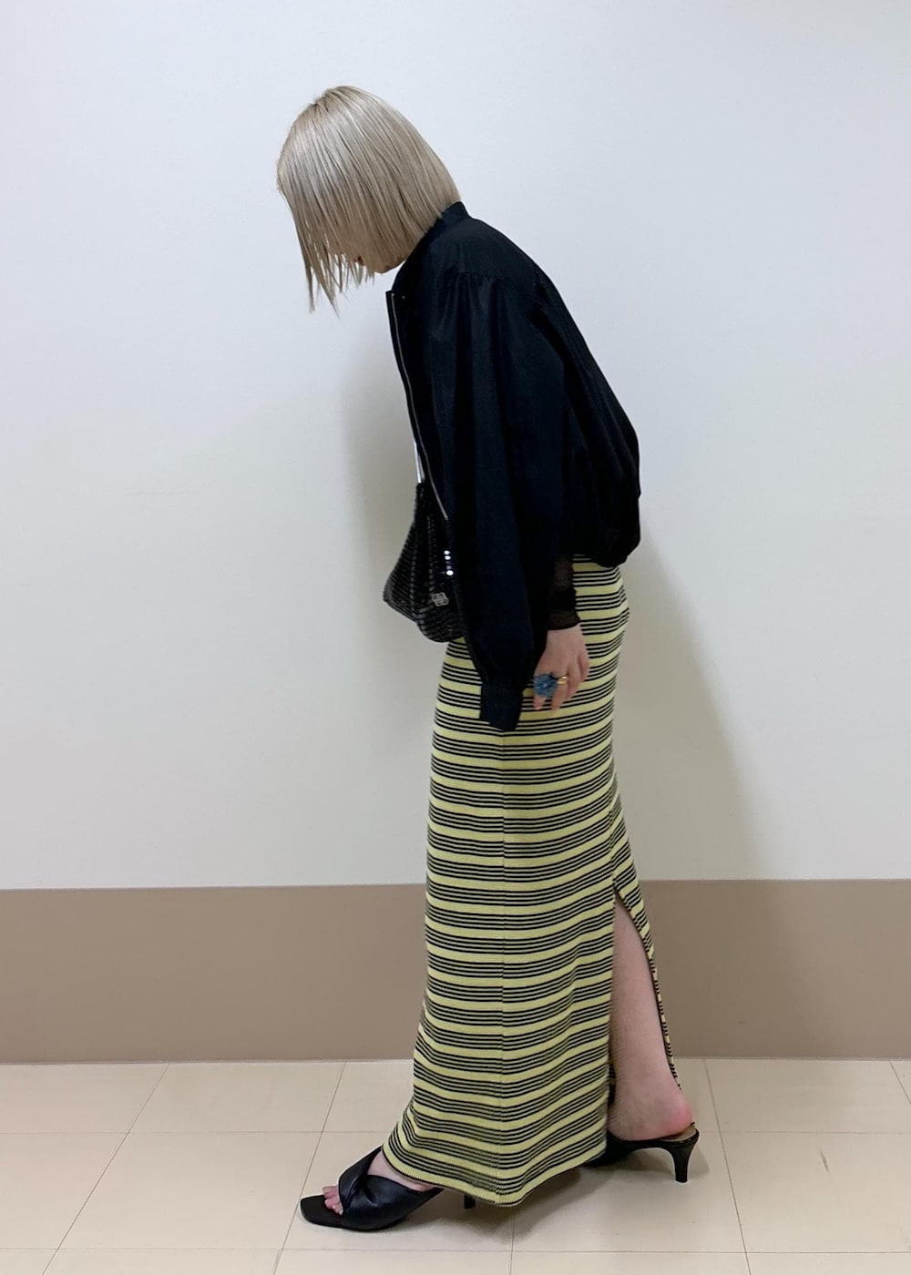 ブラック系のサンダル、グリーン系のスカート、ブラック系のTシャツ/カットソーを着用したレディースの春コーディネートの2枚目の写真