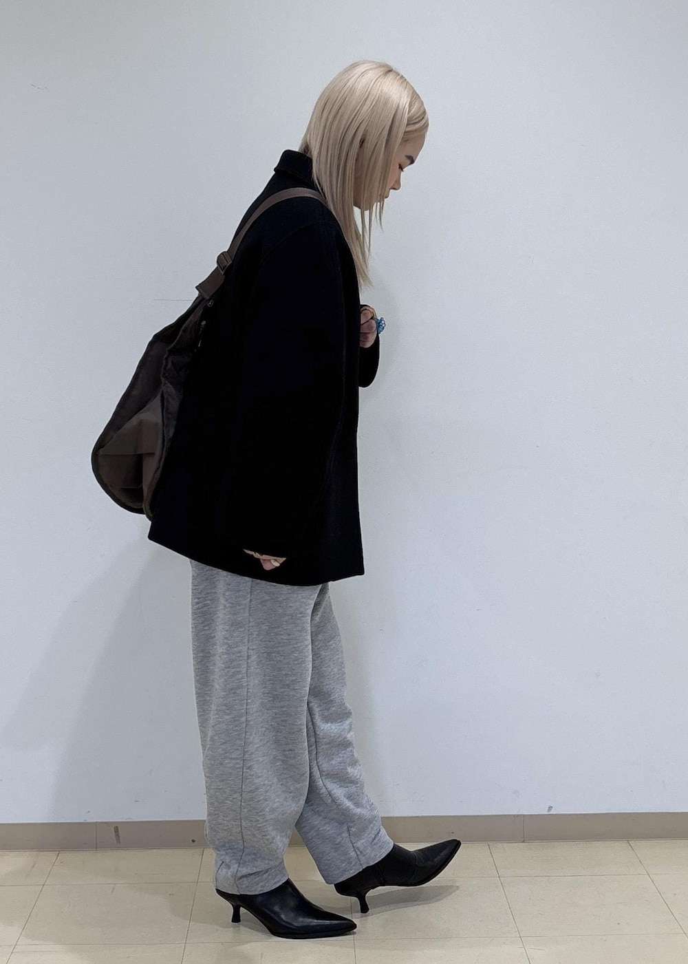 ブラック系のブーツ、グレー系のその他パンツ、ブラウン系のショルダーバッグを着用したレディースの冬コーディネートの4枚目の写真
