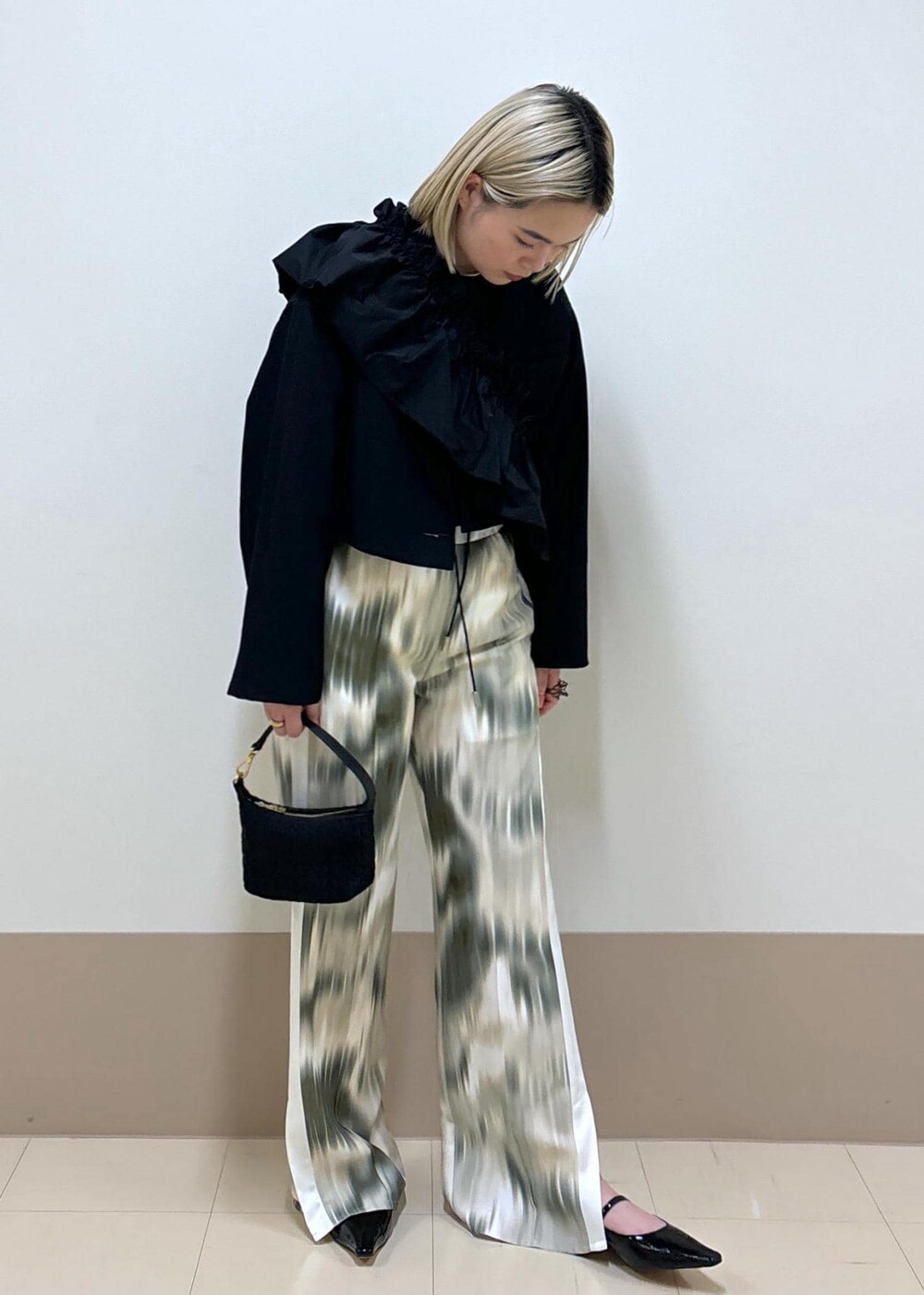 ブラック系のワンピース、ブラック系のその他シューズ、ベージュ系のその他パンツを着用したレディースの春コーディネートの5枚目の写真