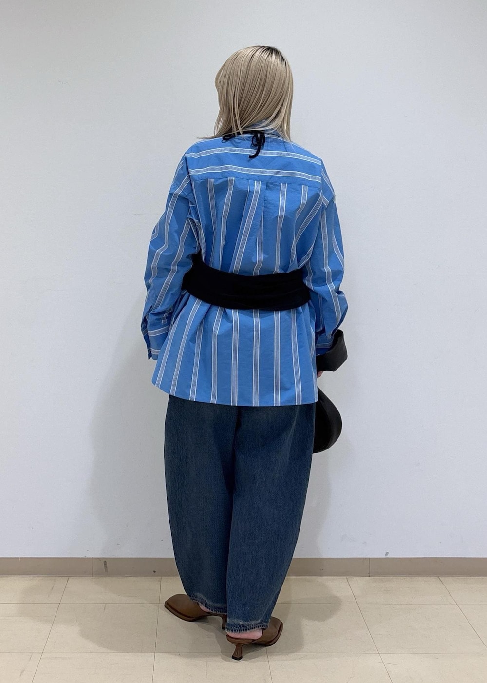 ブラウン系のサンダル、ブルー系のシャツ/ブラウス、ブラック系のTシャツ/カットソーを着用したレディースの春コーディネートの3枚目の写真