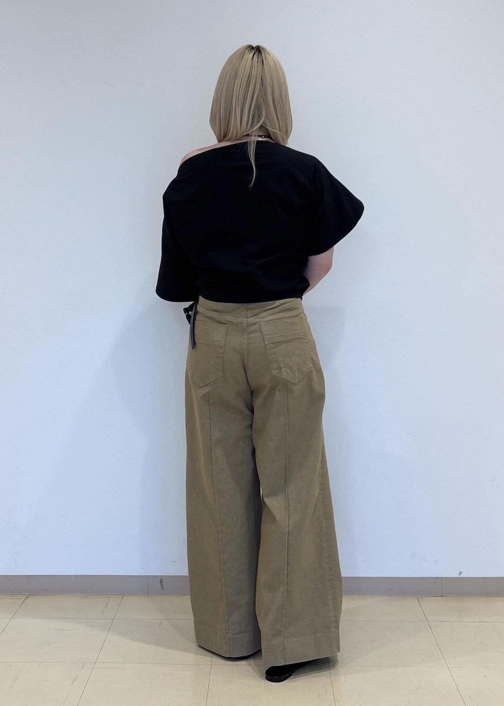 ブラック系のパンプス、ブラック系のショルダーバッグ、ベージュ系のデニムパンツを着用したレディースの春コーディネートの3枚目の写真