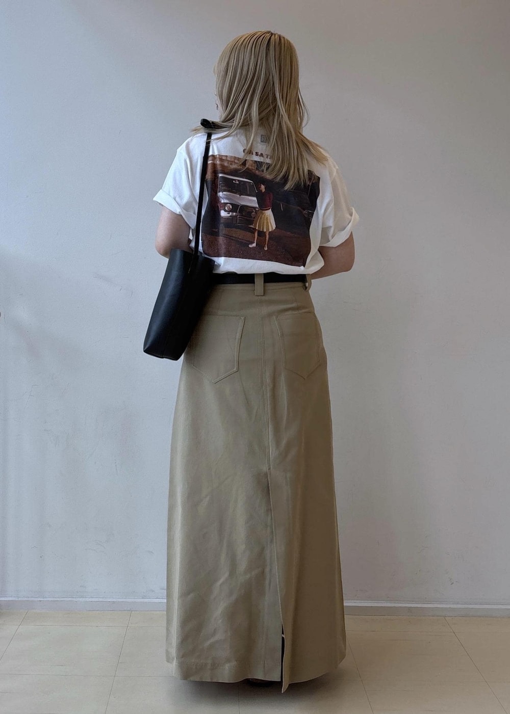 ホワイト系のTシャツ/カットソー、ベージュ系のスカート、ブラック系のショルダーバッグを着用したレディースの夏コーディネートの3枚目の写真