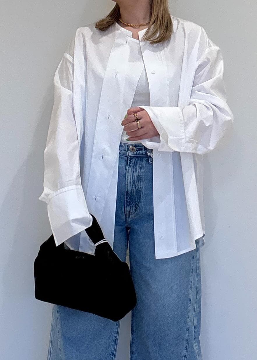 ブルー系のデニムパンツ、ブラック系のサンダル、ブラック系のハンドバッグを着用したレディースの春コーディネートの5枚目の写真