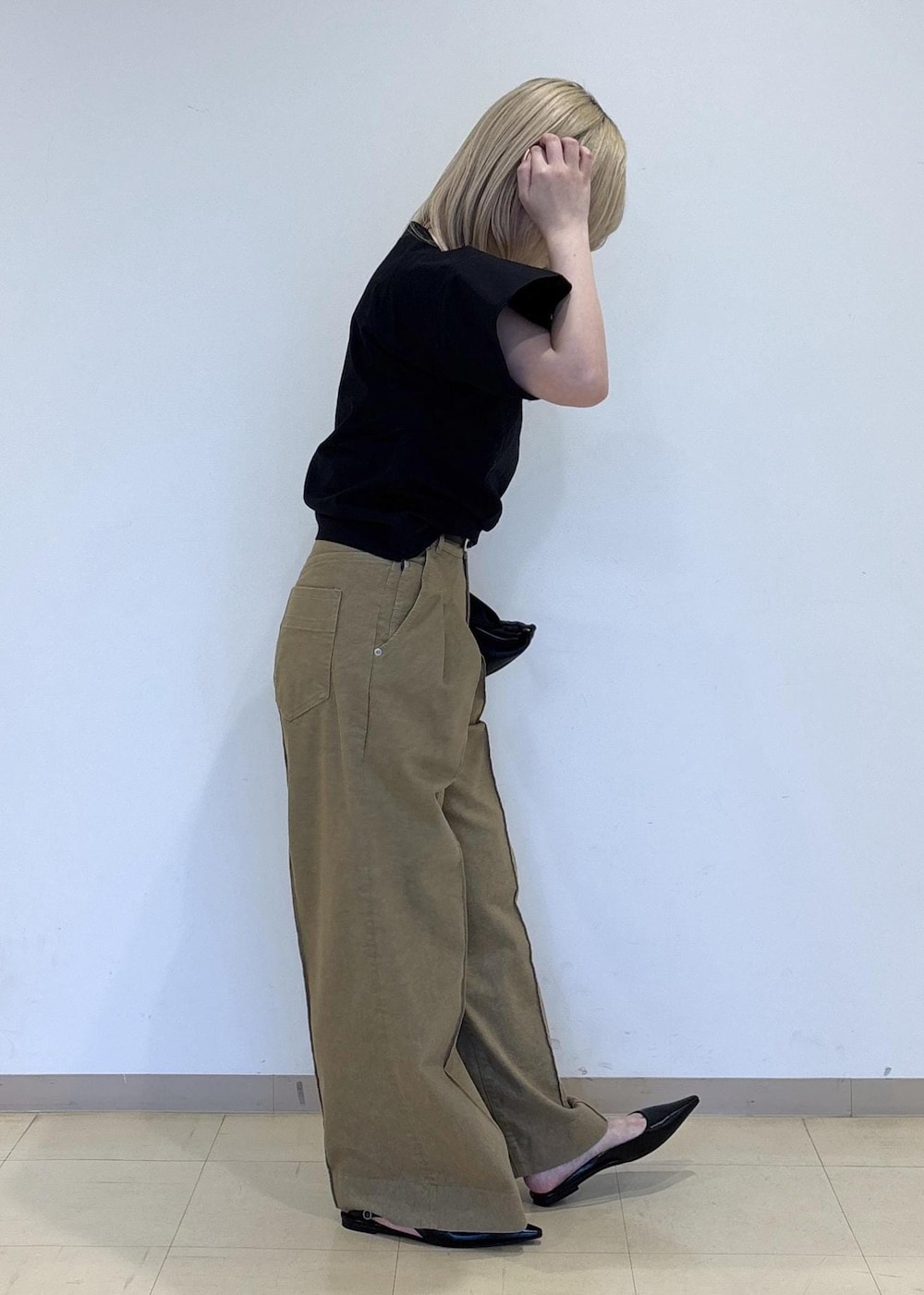 ブラック系のパンプス、ブラック系のショルダーバッグ、ベージュ系のデニムパンツを着用したレディースの春コーディネートの4枚目の写真