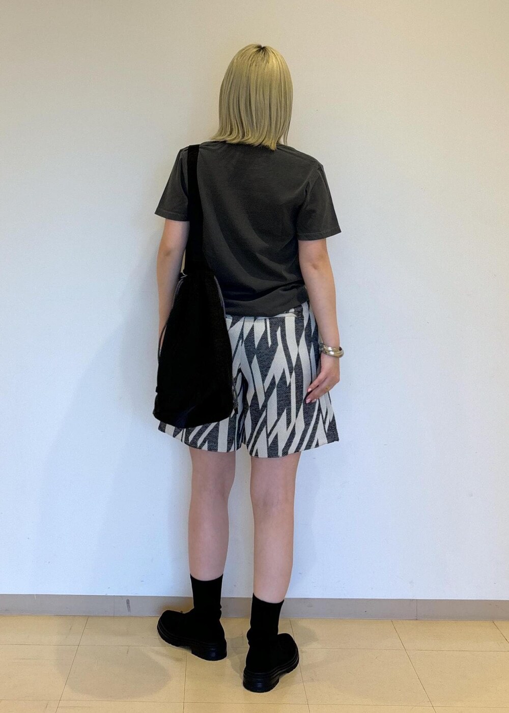 ブラック系のブーツ、ブラック系のショルダーバッグ、ブラック系のその他パンツを着用したレディースの春コーディネートの3枚目の写真