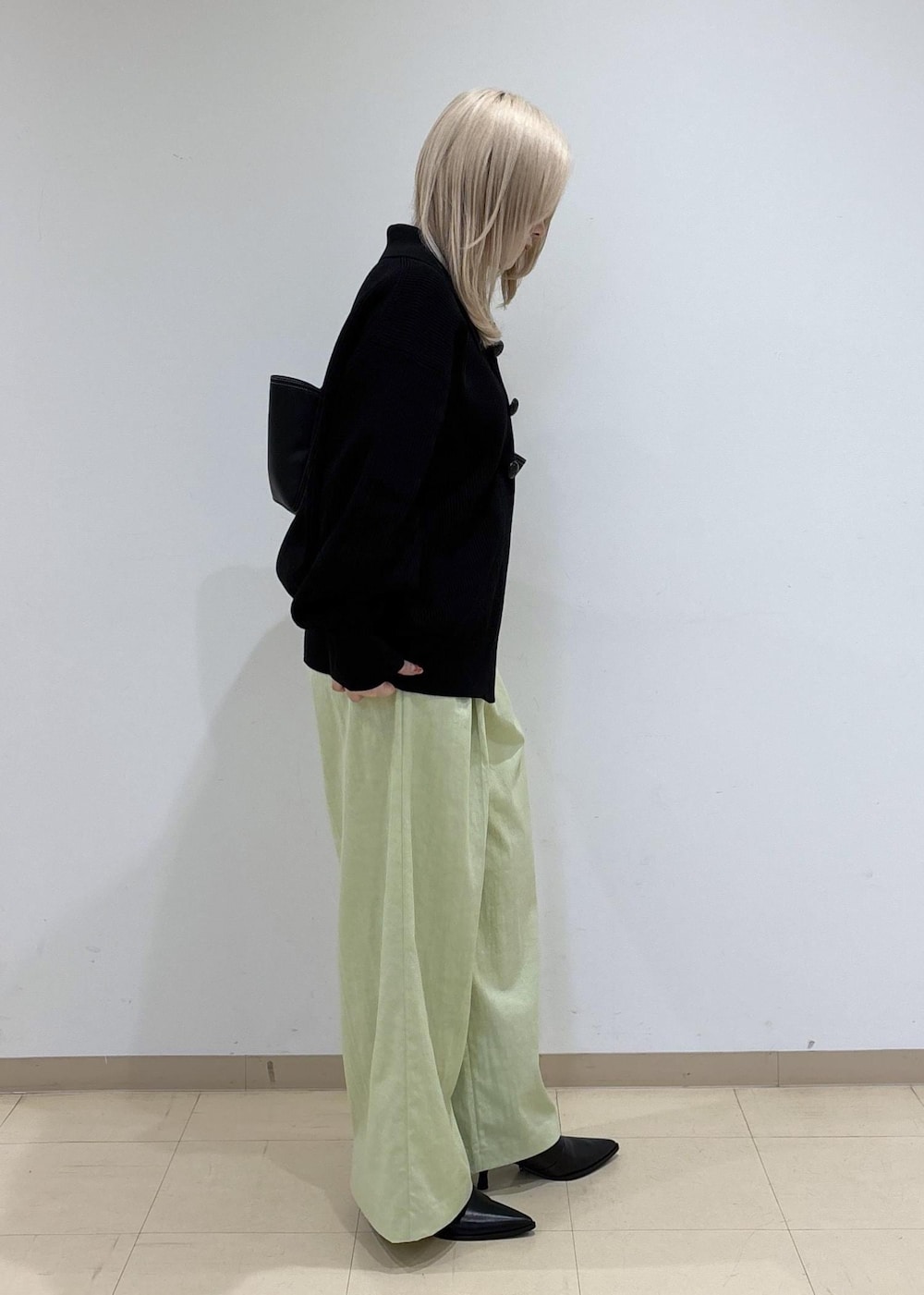 ブラック系のカーディガン/ボレロ、ブラック系のブーツ、グリーン系のその他パンツを着用したレディースの秋コーディネートの4枚目の写真