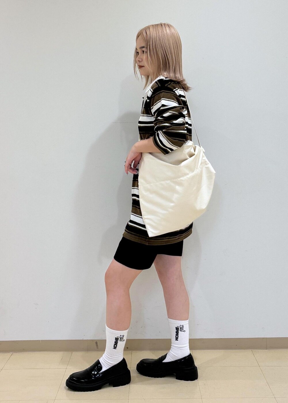 ブラック系のその他パンツ、ブラック系のローファー、ホワイト系のボディバッグ/ウエストポーチを着用したレディースの秋コーディネートの2枚目の写真