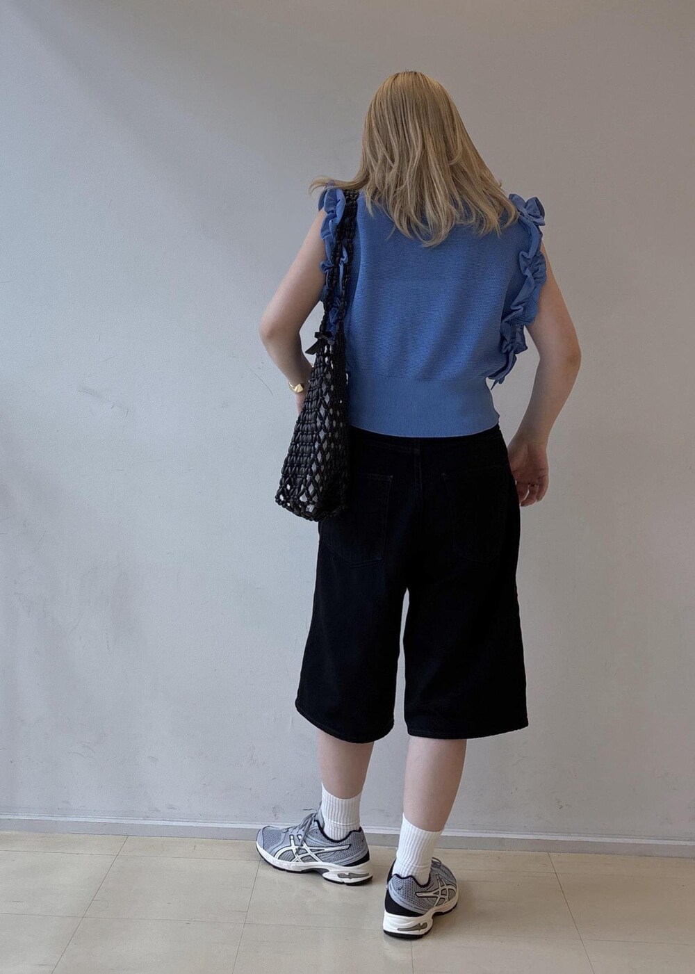 ブラック系のトートバッグ、ブラック系のデニムパンツ、グレー系のスニーカーを着用したレディースの夏コーディネートの3枚目の写真