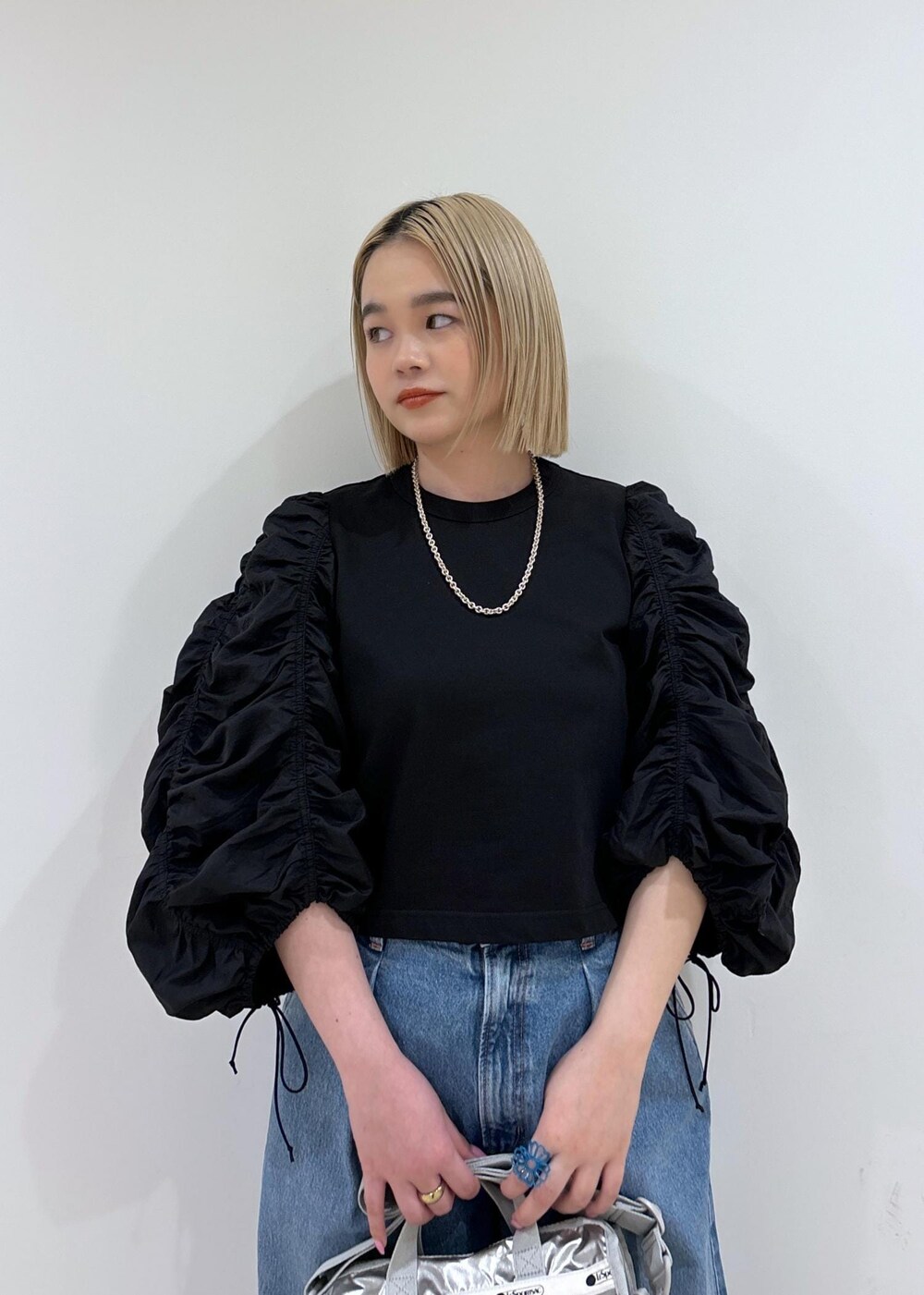 ブルー系のデニムパンツ、シルバー系のショルダーバッグ、シルバー系のサンダルを着用したレディースの春コーディネートの5枚目の写真