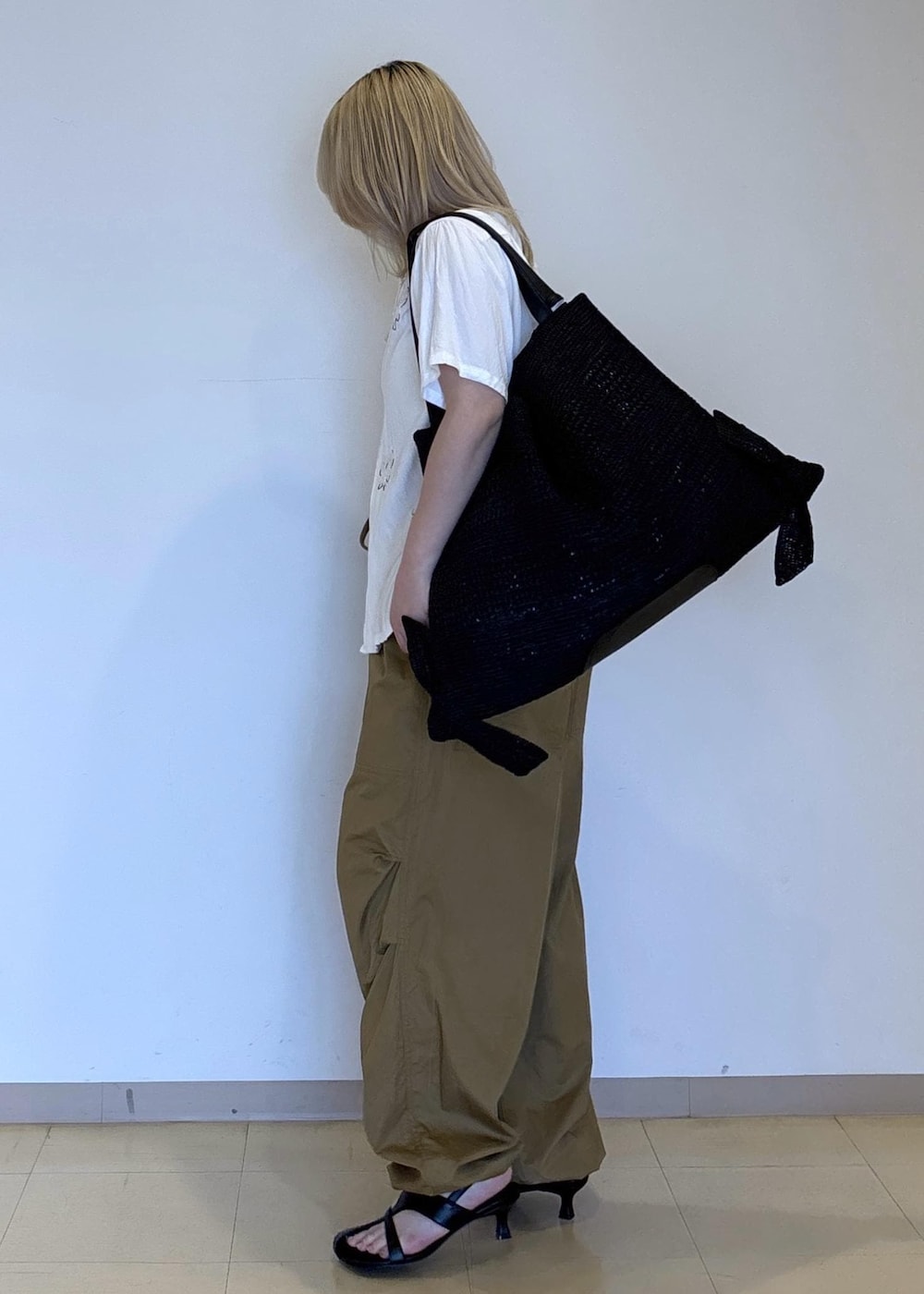 ブラック系のサンダル、ブラック系のその他パンツ、ホワイト系のシャツ/ブラウスを着用したレディースの春コーディネートの2枚目の写真