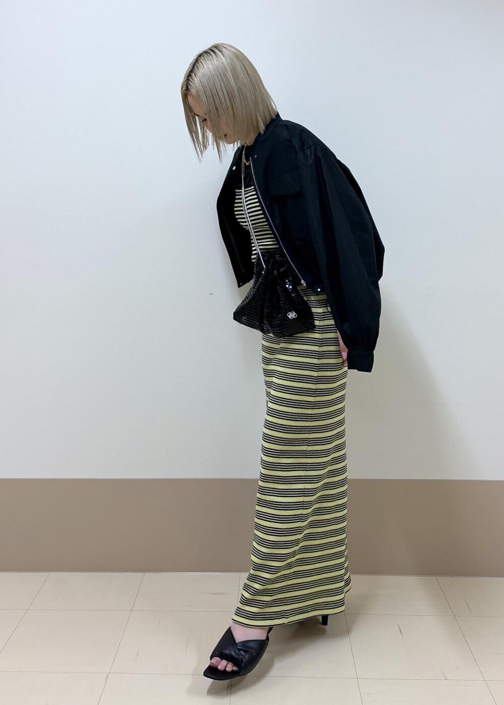 ブラック系のサンダル、グリーン系のスカート、ブラック系のTシャツ/カットソーを着用したレディースの春コーディネートの3枚目の写真