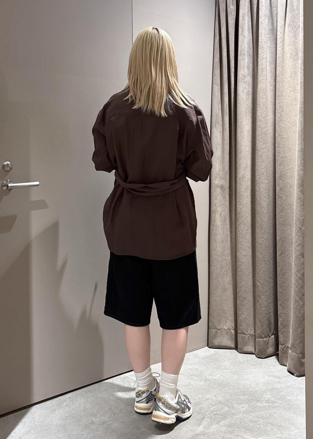 ブラック系のショルダーバッグ、ブラック系のデニムパンツ、ブラウン系のテーラードジャケットを着用したレディースの春コーディネートの3枚目の写真